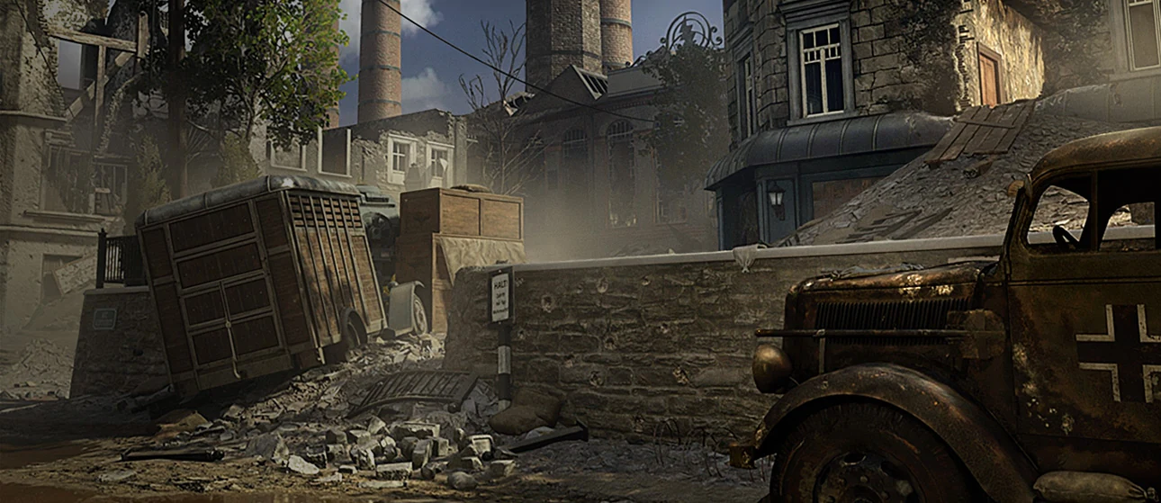 A wide view of a war-damaged town in Call of Duty: WWII, with rubble, buildings and military vehicles